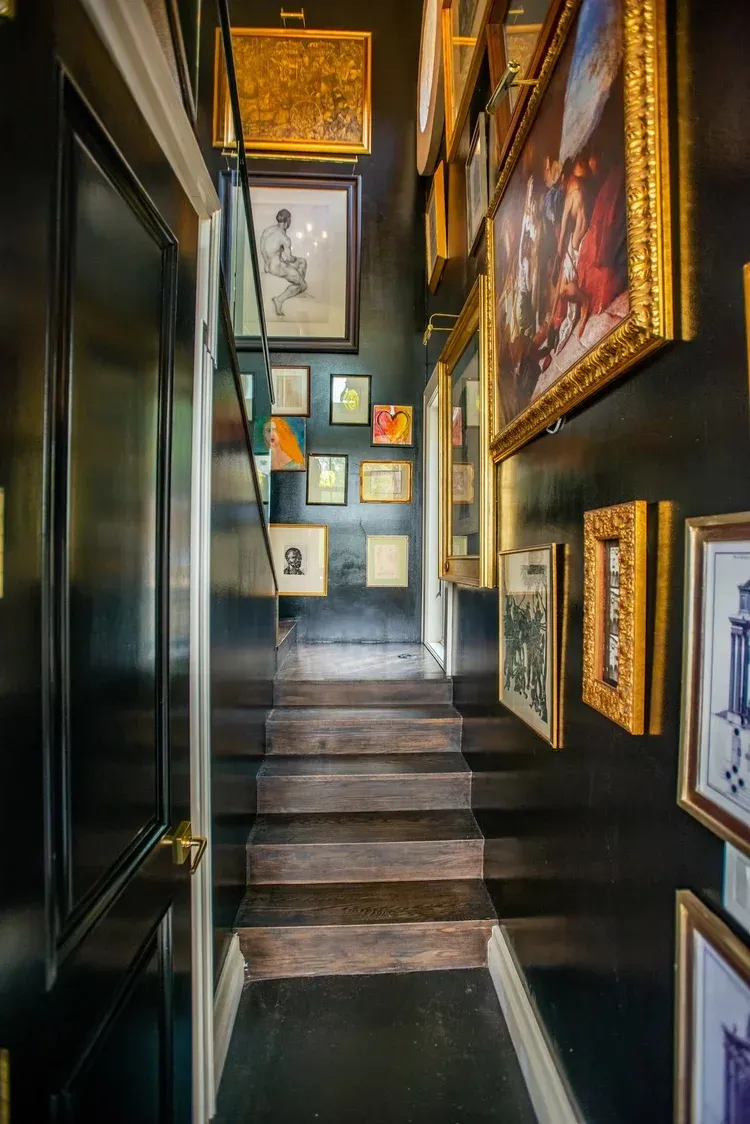 Dark gallery stair lined with framed artwork